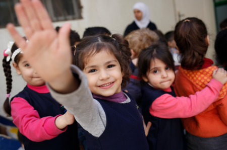 The refugee children wave while going to school